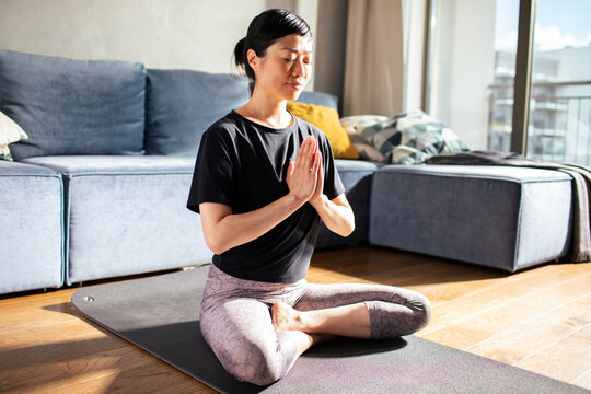 Woman doing yoga at home meditating