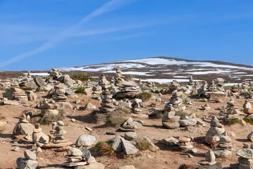 Foto auf Alu-Dibond A serene view of hand-crafted stone pyramids by visitors, symbolizing the Arctic Circle, near the Arctic Circle Center in Rana, Nordland, Norway © Artem