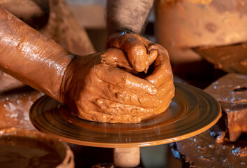 Professional potter making bowl in pottery workshop, studio.