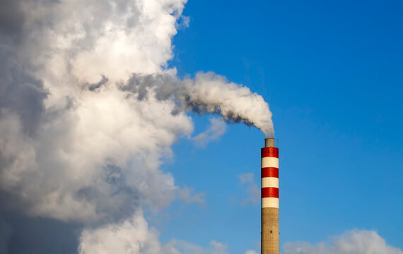 Factory chimney smoke with blue sky and clouds