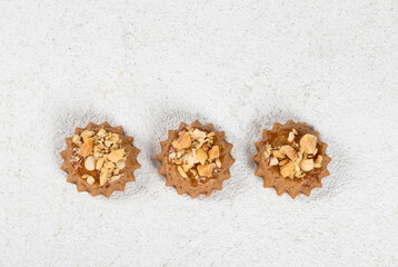 Small cookies with caramel and peanuts. White background. Top view