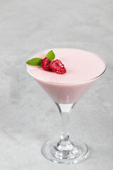 Vegan Raspberry cream jelly, Panna Cotta in a martini glass. Light gray background. Copy space