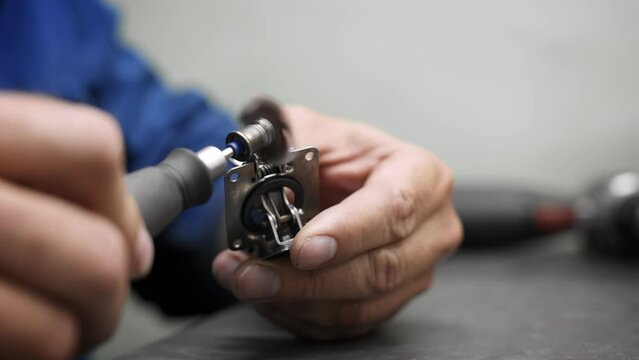 Close-up of an engineer's hands polishing a metal part