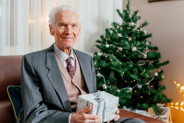 Smiling Joyful Senior Man Holding Christmas Gift In Hands Xmas Holidays