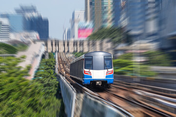 Electric train rushes motion speed blur effect among trees and a park in a metropolis