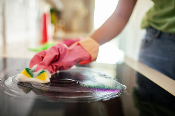 Woman using sponge to clean kitchen
