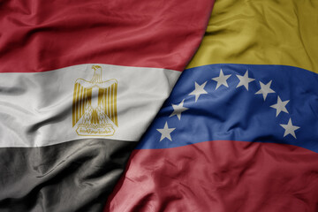 big waving national colorful flag of venezuela and national flag of egypt .