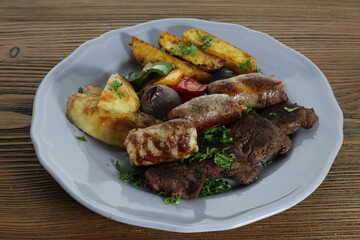 beef tikka kabab and sausage with potato veggies served in dish isolated on table top view of arabic food