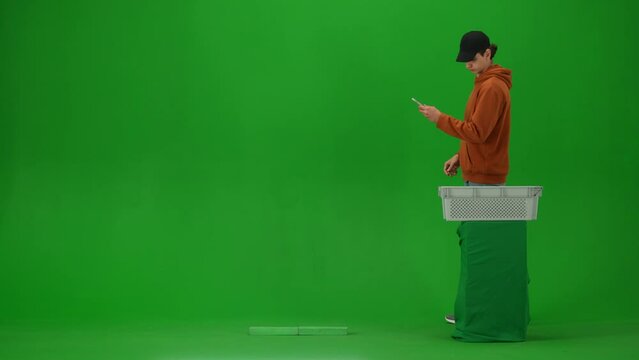 Portrait of traveler isolated on chroma key green screen background. Man walks through metal detector at the airport taking off metal things.