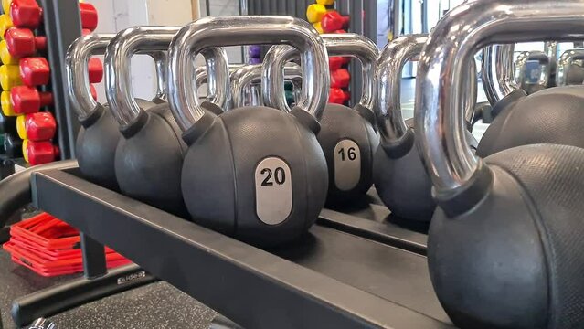 Man hand takes dumbbells for bodybuilding in gym. Closeup of man's hands lifting weights in sports club