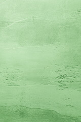 Green textured concrete background with light base darker in the recesses. Abstract texture for graphic design or wallpaper, top view