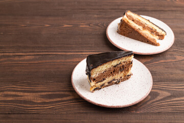 Chocolate biscuit cake with caramel cream on brown wooden. side view, copy space.