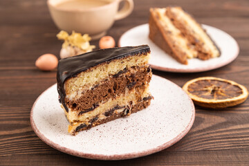 Chocolate biscuit cake with caramel cream on brown wooden. side view, selective focus