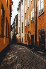 view in morning beautiful light of narrow street in old town with orange walls in stockholm
