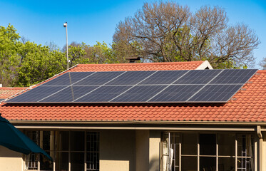 Solar panels, aimed at mitigating 'load-shedding' or blackouts, are seen on a residential roof in a...
