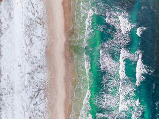 Fototapeta na wymiar Aerial view of Baltic sea with snowy beach at winter.