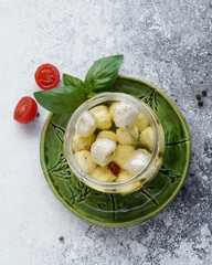 small balls of mozzarella cheese in a jar, top view, no people, light background