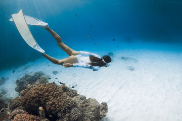 Freediver with fins dive underwater. Freediving with beautiful lady in clear blue ocean