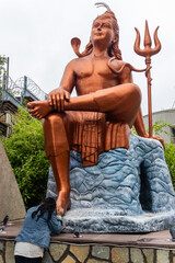 young girl paying salutation to hindu god lord shiva statue at morning from flat angle