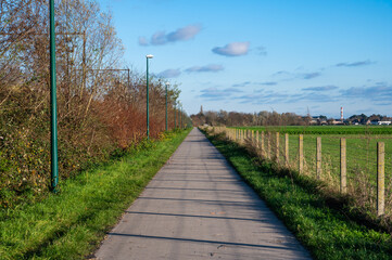 Londerzeel,  Belgium -  Asphalt biking path along the railway track through the Flemish countryside