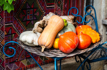 travel to Georgia - harvest of various ripe pumpkins and squash on table in courtyard of peasant...