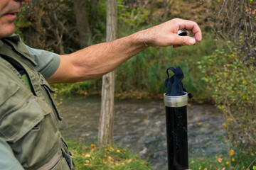 Angler preparing for his day's fishing by taking his fly fishing rod out of its case.