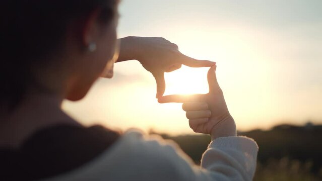 Travel freedom a concept, Close up of traveler woman hands making frame gesture with sunrise in summer, Female capturing the sunrise