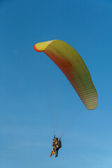 Paragliding in the sky over the sea. The concept of parachute flight. Tandem skydiver pilot and...