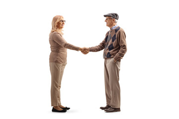 Full length profile shot of an elderly man shaking hand with a woman