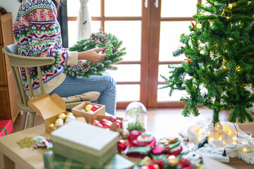 Woman making mistletoe wreath Christmas wreath decoration with hand made DIY winter greenery florist hands making Christmas wreath beautiful mistletoe.