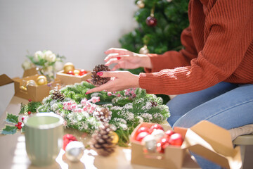 Woman making mistletoe wreath Christmas wreath decoration with hand made DIY winter greenery florist hands making Christmas wreath beautiful mistletoe.