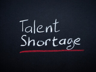 Written inscription Talent shortage on a dark surface.