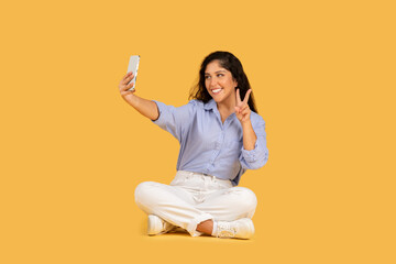 Glad latin millennial brunette woman in casual make selfie at smartphone