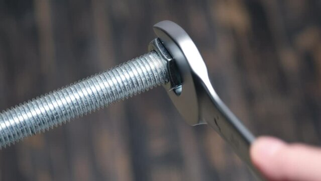 Tightening a large metal nut with a large spanner. Top view