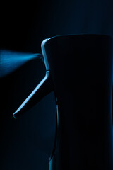 Close up of a spray gun on blue background. Spraying water. Hairdressing spray gun