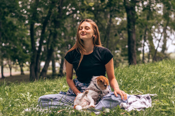 A young positive woman practicing yoga with a Jack Russell terrier dog, enjoying happy moments...