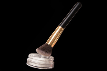 Levitation of a can of face powder with black brush. Professional cosmetics