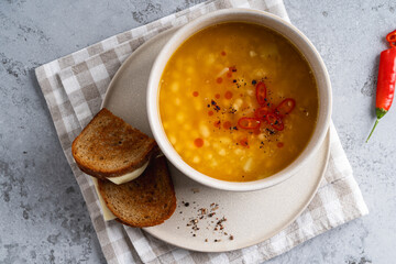 Bowl of white bean soup with rye bread cheese sandwich, healthy comfort food, top view