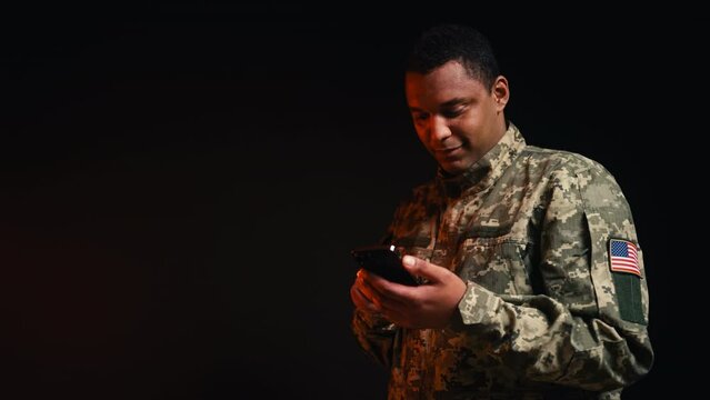 African American military with US flag patch scrolling social media on cellphone