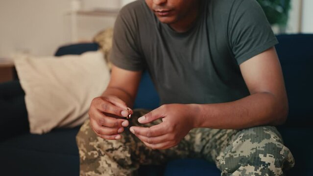Thoughtful African American soldier taking off wedding ring, separation, divorce