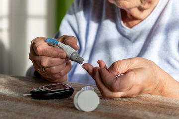 starsza kobieta bada poziom cukru we krwi - obrazy, fototapety, plakaty