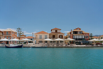 Fototapeta na wymiar Sunny coastal view with quaint seaside cafes and moored boats