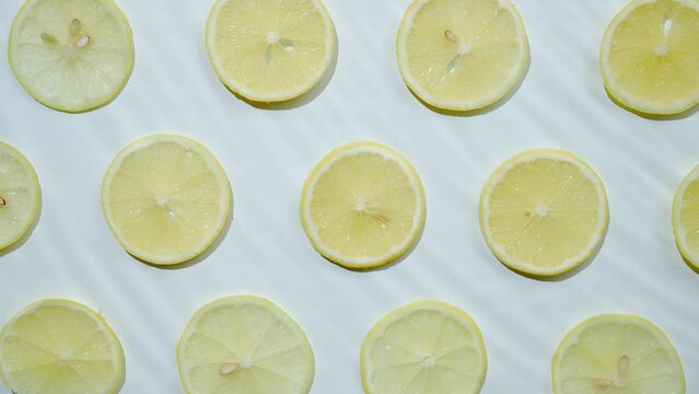 Slice of lemon underwater or in water with splashing and droplet top view flat lay on white background.