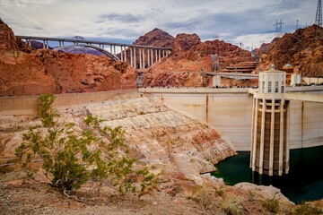 People walk across Hoover Dam with water intakes in the foreground