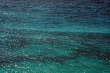 Close-up aerial shot capturing the mesmerising texture of the sunlit turquoise sea