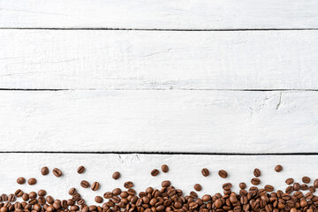 Aromatic coffee beans on white wooden table. Top view