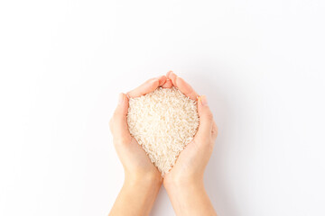 Overhead shot of woman’s hands holding white rice grains isolated on white background