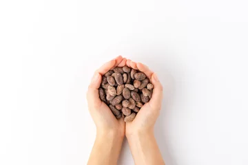 Deurstickers Overhead shot of woman’s hands holding cocoa beans isolated on white background © One Pixel Studio