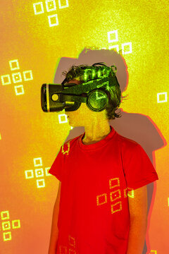 Boy in VR goggles exploring virtual reality in neon lights