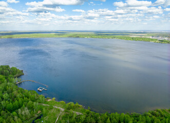 Big lake with green shores in bright sun light, aerial landscape. Recreation concept. Aerial view